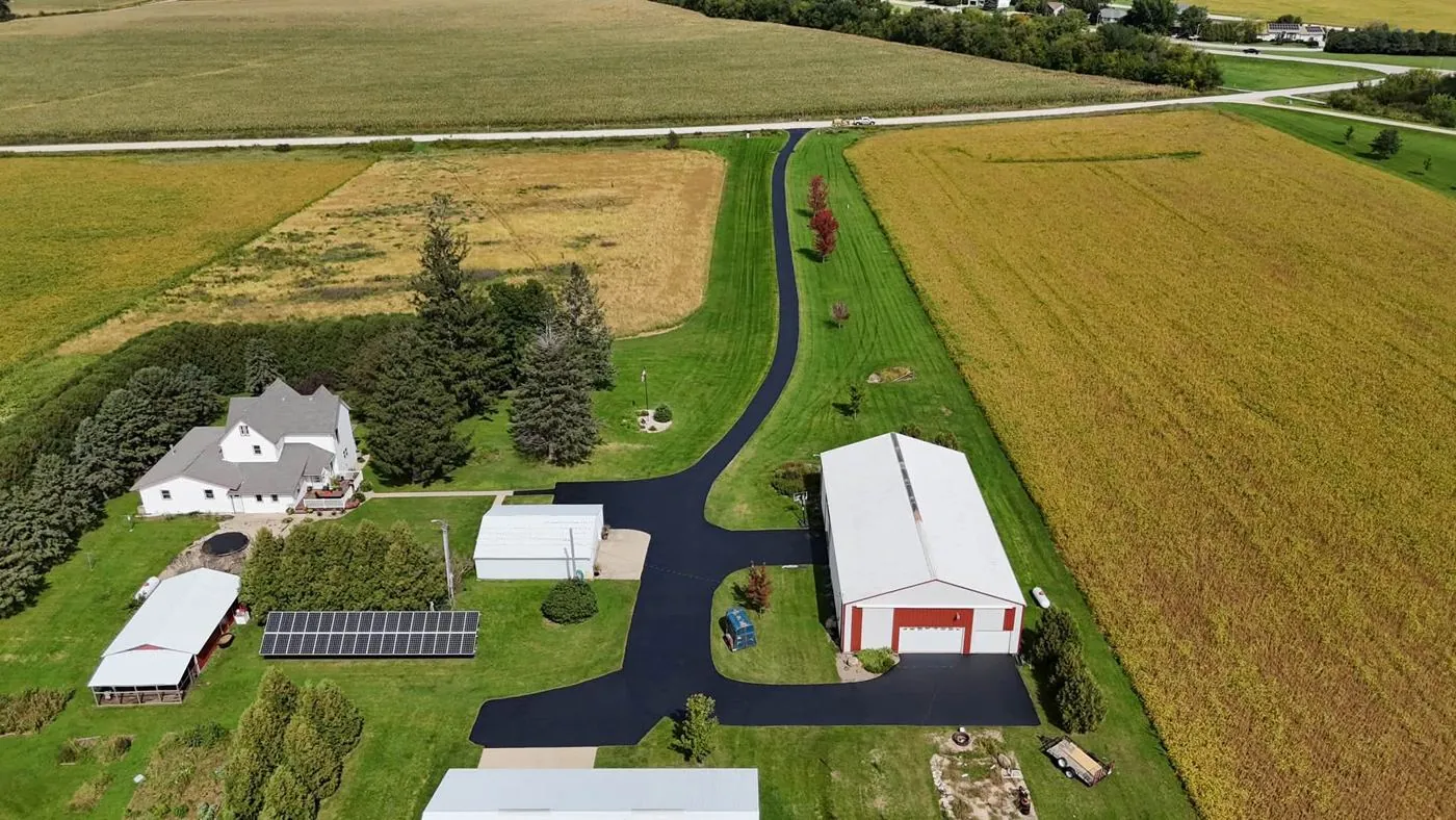 Long rural driveway in Iowa freshly sealcoated with black asphalt sealer
